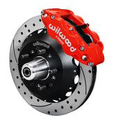 Wilwood red Superlite 6R front caliper beside the assembled 12.88-inch drilled and slotted rotor and hub for Chevrolet full-size drum-spindle