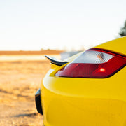 Rennline Carbon Fiber Upkick Spoiler: Elevate your 987 Cayman with this sleek, hand-laid carbon fiber spoiler for an OEM+ look. Shop now at PMB Performance.